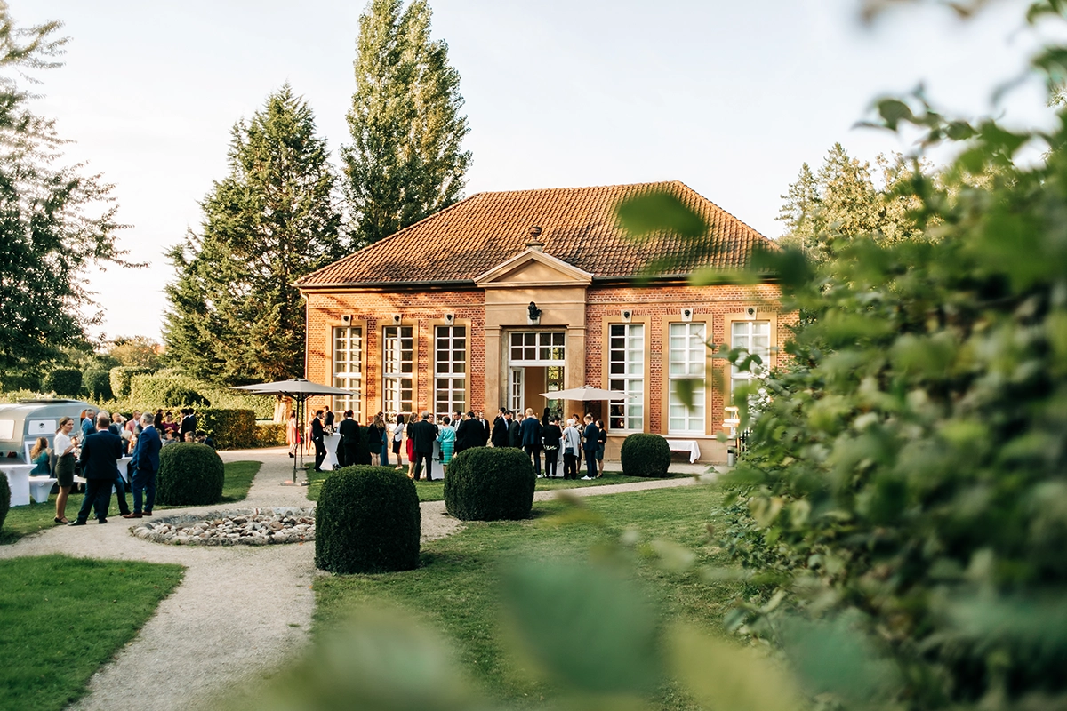 Hochzeitslocation Orangerie im Schlosspark Rheda-Wiedenbrück mit Sektempfang der Gäste im Garten
