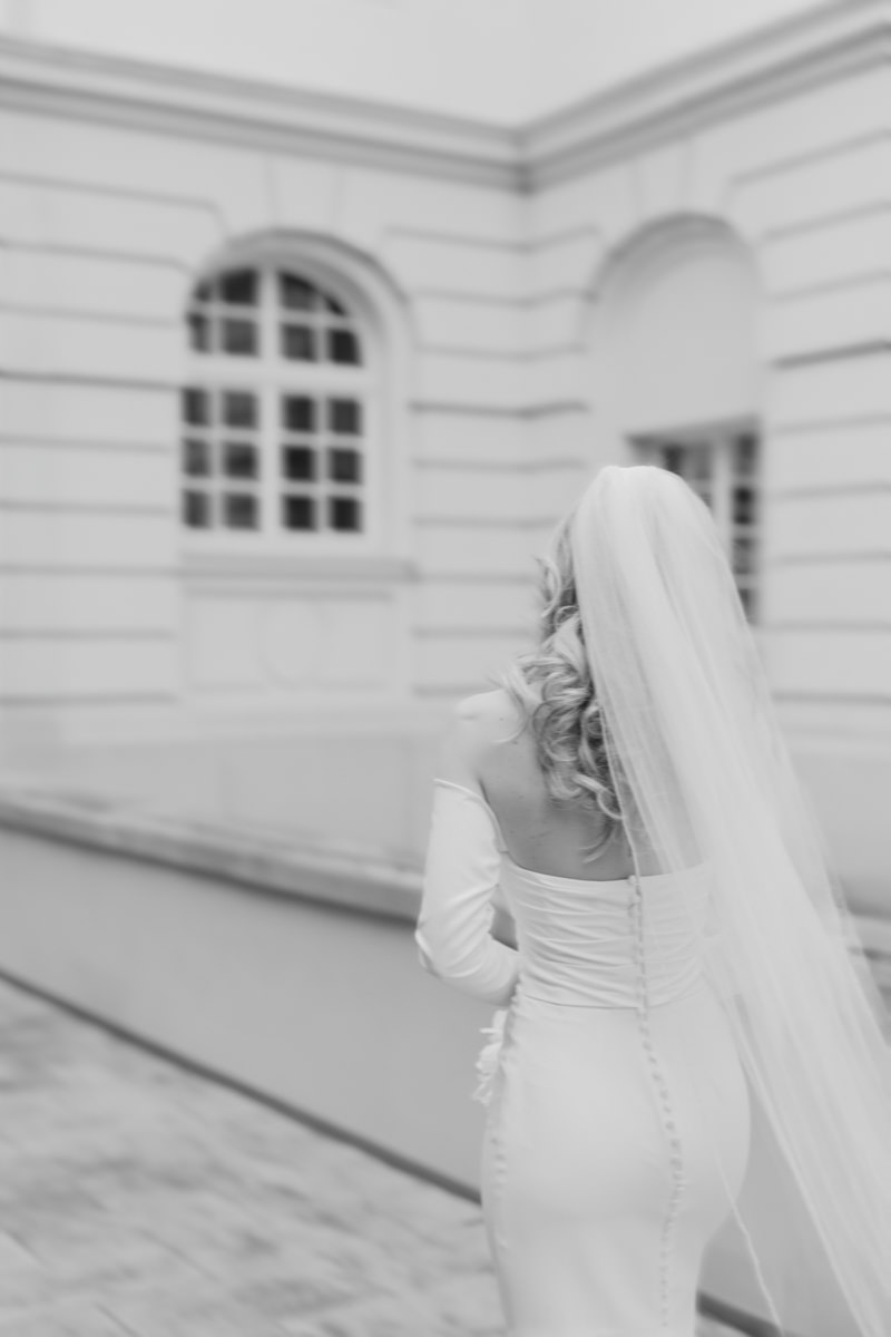 Pauline im Brautkleid mit langem Schleier am Rathausplatz