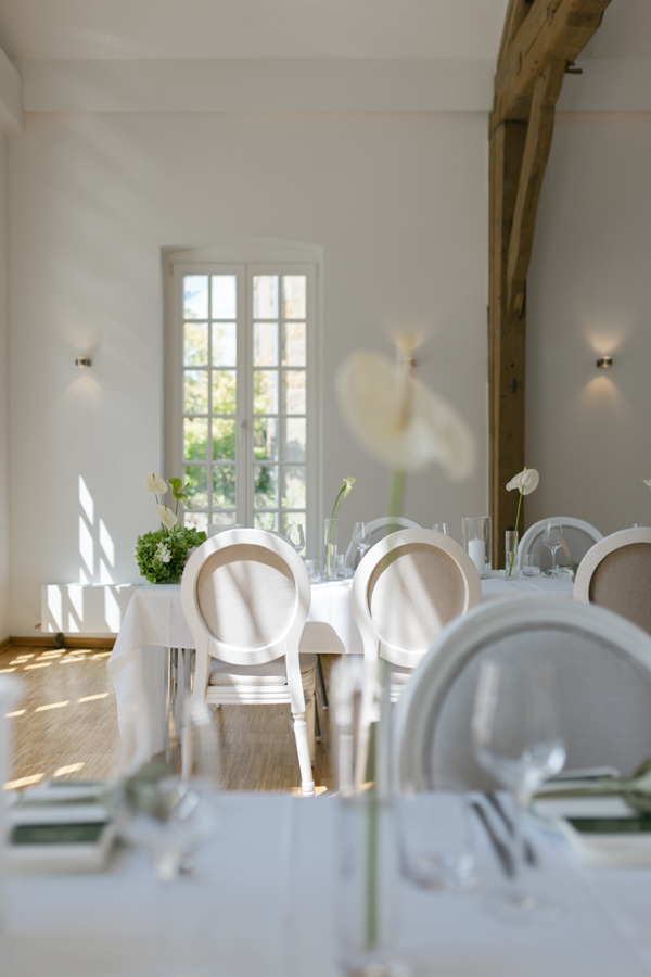 Lichtdurchflutete Orangerie des Wasserschlosses Holtfeld mit gedeckten Hochzeitstischen