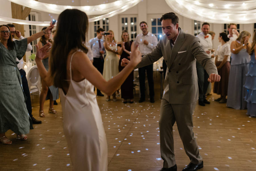 Samira und Klaus tanzen bei ihrer Hochzeitsparty mit ihren Gästen in der Orangerie