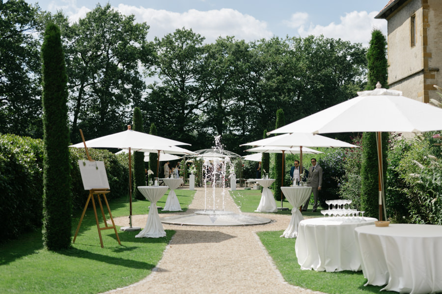 Vorbereiteter Sektempfang mit Stehtischen, Sonnenschirmen und Brunnen im Schlossgarten